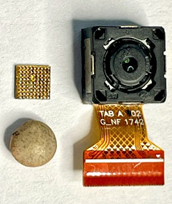 Cámara de un teléfono móvil completa junto al CAD y la lenteja, a tamaño casi natural